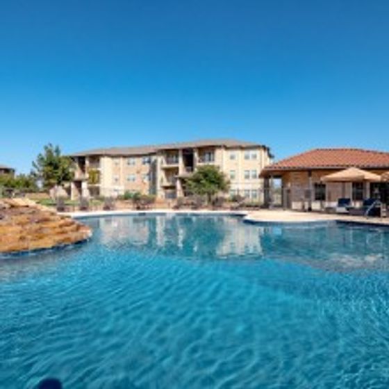 Resort Inspired Swimming pool overlooking property buildings