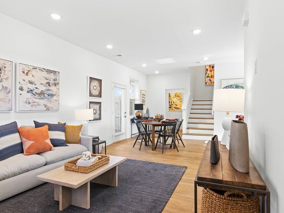Inviting open-concept living and dining area with modern decor, cozy furniture, and elegant artwork, ideal for stylish living.