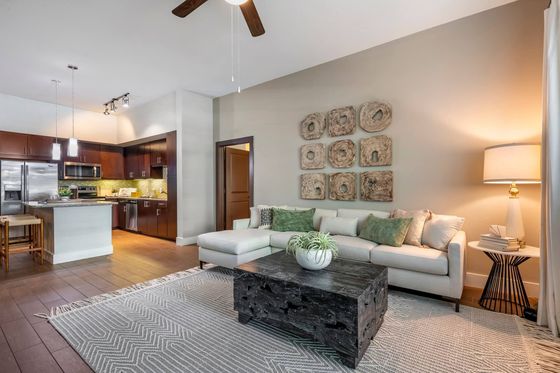 Elegant, open-concept living room with stylish decor, plush sectional sofa, and modern kitchen perfect for entertaining.