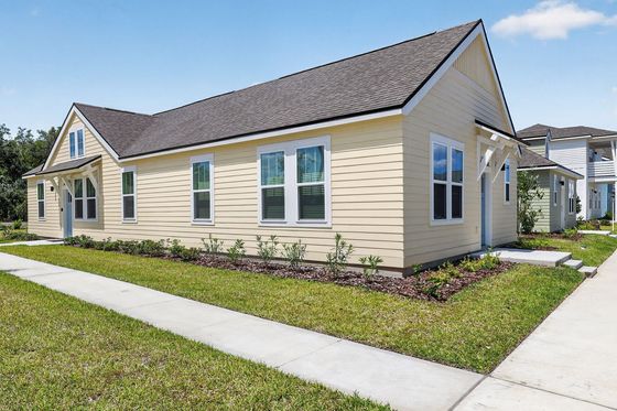 Charming single-story yellow house with a neatly landscaped garden and modern architecture.