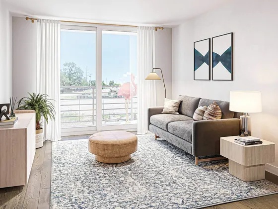 Bright and modern living room with elegant decor, featuring a cozy gray sofa, stylish wooden furniture, and a large window with a scenic view.