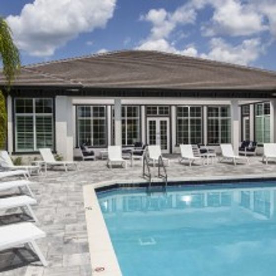 Amberton Luxury Townhomes, exterior, sparkling blue swimming pool, white lounge chairs, clubhouse, large windows