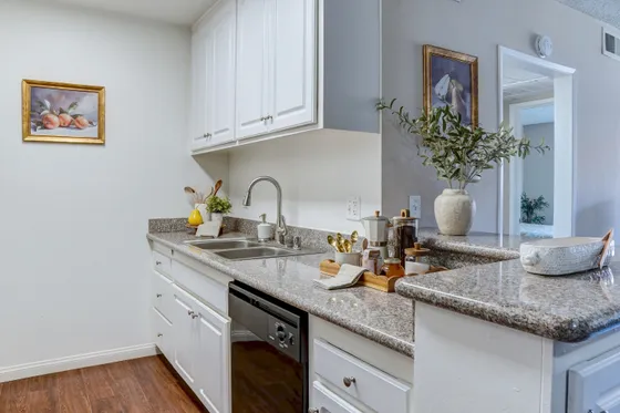 Charming kitchen with elegant granite countertops, stylish white cabinets, and tasteful decor creating a welcoming ambiance.