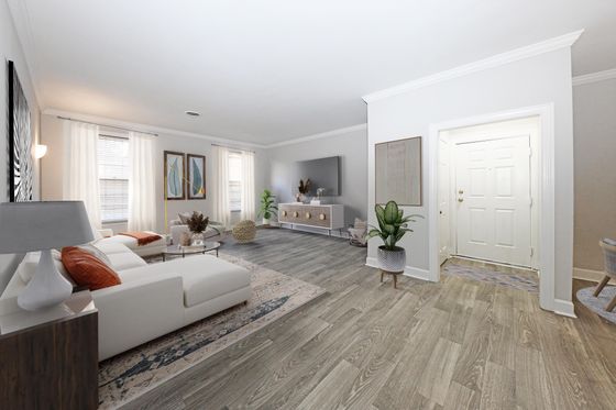 Contemporary living room with elegant decor, featuring a white sectional sofa, wooden flooring, and natural light.