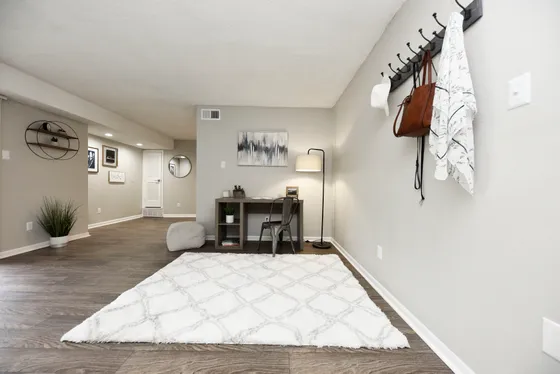 Bright and modern study nook with elegant decor, featuring a sleek desk, cozy lighting, and stylish wall art in a spacious open-concept apartment.