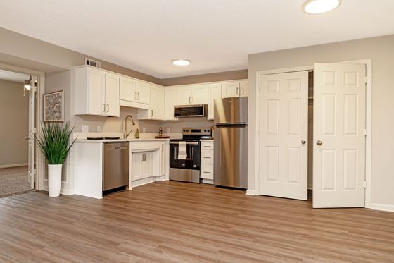 Modern kitchen with stainless steel appliances, sleek cabinetry, and hardwood floors, perfect for contemporary living.