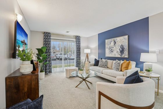 Chic and modern living room featuring a cozy white sofa with colorful cushions, elegant decor, and large windows for abundant natural light.