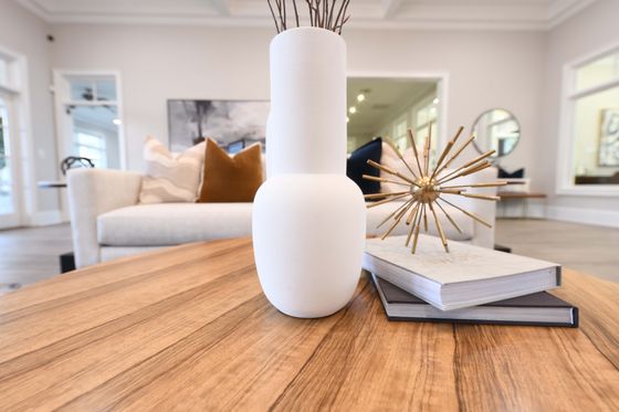 Elegant living room table with a modern white vase, decorative sculpture, and stylish books creating a sophisticated ambiance.