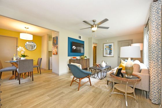 Modern living room with stylish decor, featuring elegant wood flooring, a comfortable seating area, and a cozy dining nook with ambient lighting.