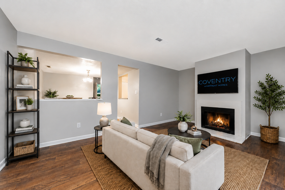 Inviting living room with a cozy fireplace, modern decor, and elegant lighting in Coventry Apartment Homes.