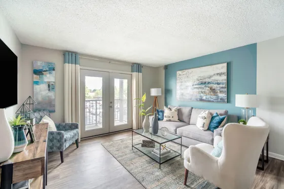 Modern and inviting living room with stylish furniture and elegant decor, featuring a large window for natural light and a cozy seating area.