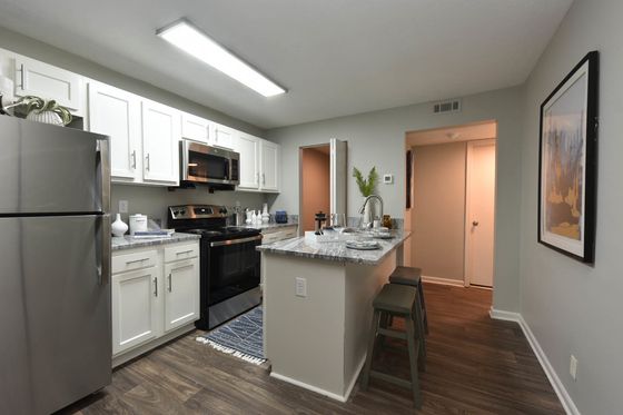 Modern kitchen with stainless steel appliances, sleek granite countertops, and stylish white cabinetry, offering a cozy and inviting atmosphere.
