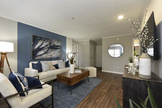 Chic modern living room with stylish blue accent wall, elegant artwork, and cozy seating area.