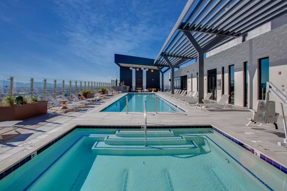Luxurious rooftop pool with modern loungers and breathtaking city views.