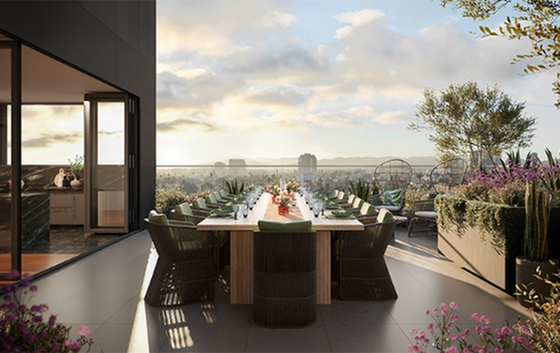 Elegant rooftop terrace with a dining area offering breathtaking city views, lush greenery, and cozy seating.