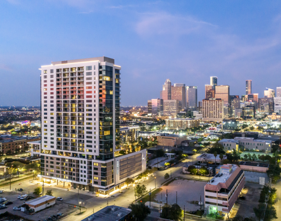 Modern high-rise apartment building with stunning city skyline views at twilight, offering urban luxury and vibrant living.