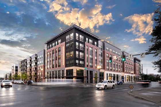 Exquisite urban apartment complex with modern architectural design, set against a vibrant sunset sky.
