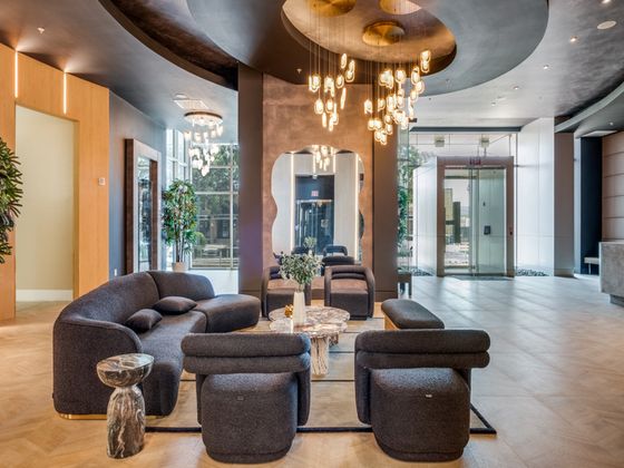 Chic modern lobby with elegant seating, stunning chandeliers, and floor-to-ceiling windows offering natural light and sophistication.