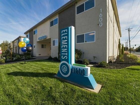Exterior visual with monument sign and balloons on the lawn.