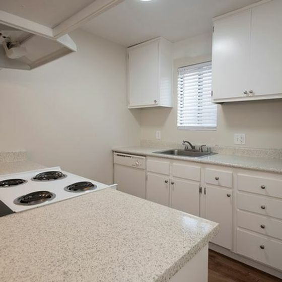 kitchen view with white cabinets, electric stove, a window above kitchen sink