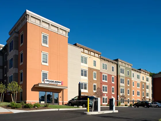 Modern apartment complex with colorful façades and large windows, offering contemporary urban living.