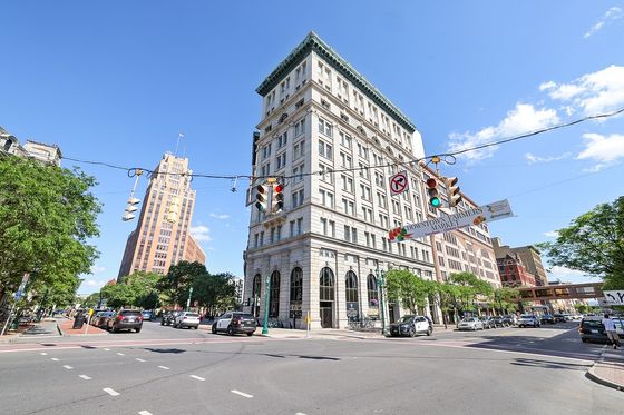 Charming urban corner featuring historic architecture, a vibrant downtown scene, and a bustling intersection under a clear blue sky.