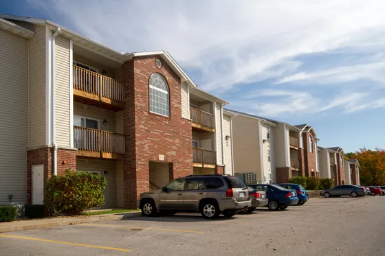 Charming apartment complex with brick accents, private balconies, and convenient parking.