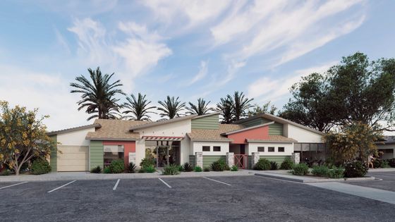 Charming modern apartment building with a vibrant facade, surrounded by lush greenery and palm trees, offering ample parking space under a serene blue sky.
