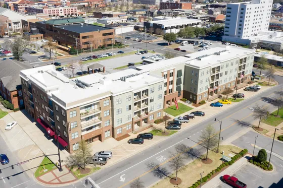 Aerial view of modern apartment complex in a vibrant city neighborhood.