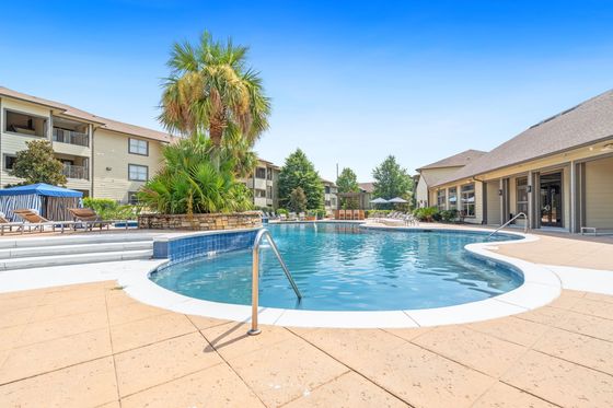 Beautiful pool featuring a cabana, grilling area, fir pit, and variety of seating
