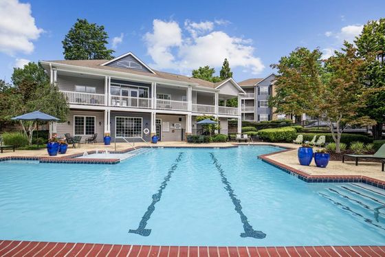 Swimming pool with leasing office in the background, blue pottery with plants
