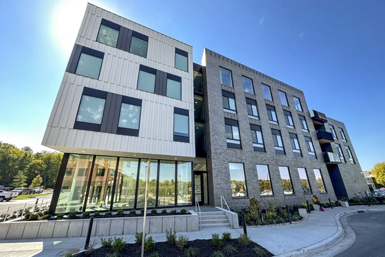 Modern apartment building with a sleek design and large windows, offering a bright and inviting atmosphere in a vibrant neighborhood.