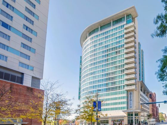 Contemporary high-rise building showcasing modern architecture with expansive glass windows and curved design, perfect for city living.