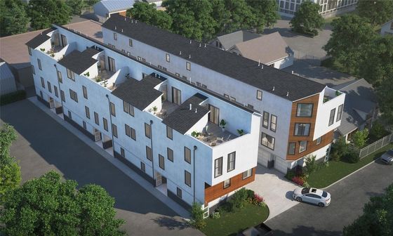 Modern apartment complex with sleek design, featuring private rooftop terraces and lush landscaping, offering a stylish urban living experience.