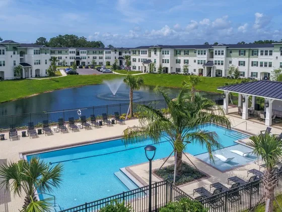 Beautiful pool with lake and buildings in background