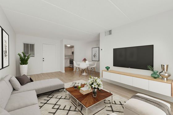 Chic and modern apartment living room with sleek furniture, elegant decor, and a bright, open-concept design featuring a cozy sofa, stylish coffee table, and wall-mounted TV.