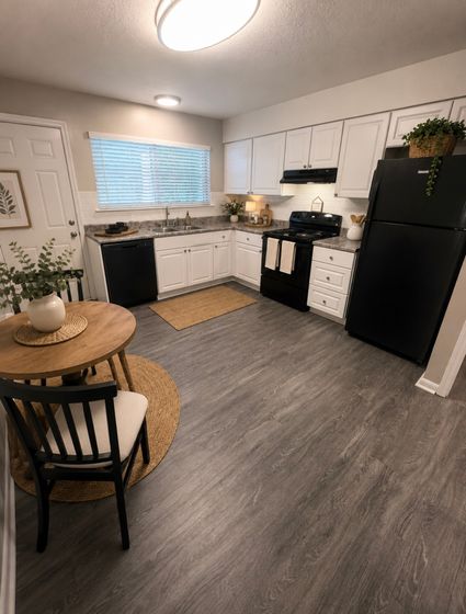 Charming kitchen with modern appliances, elegant white cabinetry, and cozy dining space, featuring stylish decor and natural light.