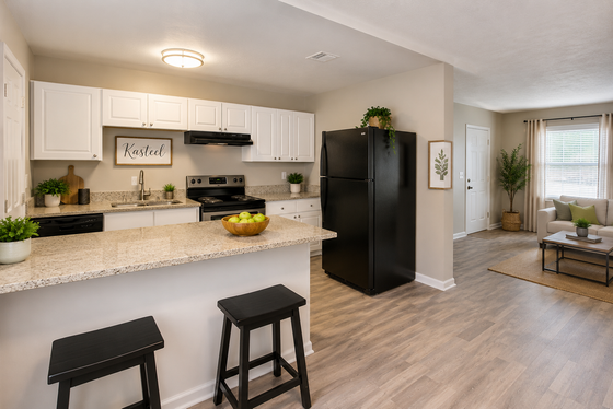 Modern open-concept kitchen with elegant granite countertops and cozy living room, showcasing stylish interior design and abundant natural light.