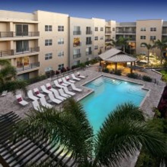 Mosaic Westshore, exterior, aerial view, property, sparkling blue swimming pool, palm trees, lounge chairs, four levels,