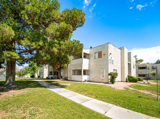 Charming apartment complex with modern architecture, surrounded by lush greenery and a well-maintained garden.