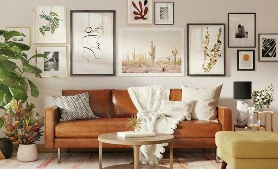 brown leather sofa with many art frames hanging behind
