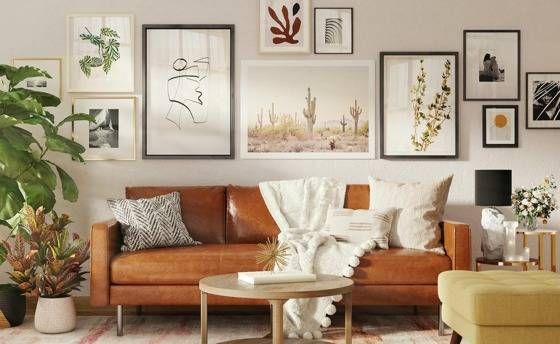brown leather sofa with many art frames hanging behind