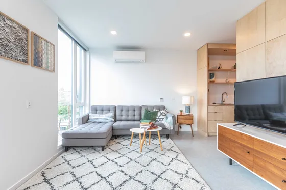 living room with grey sofa and white area rug at Artisan