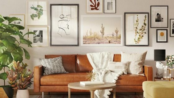 brown leather sofa with many art frames hanging behind