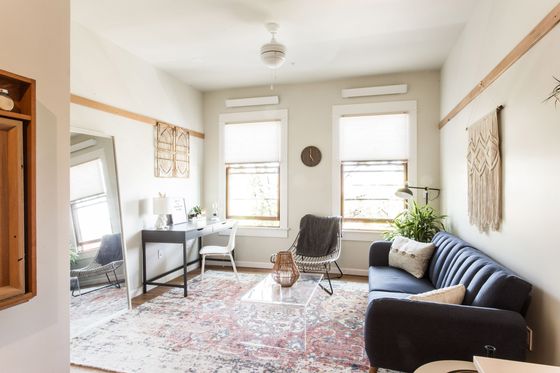 living room with blue sofa large persian rug with glass coffee table at fairmount apartments
