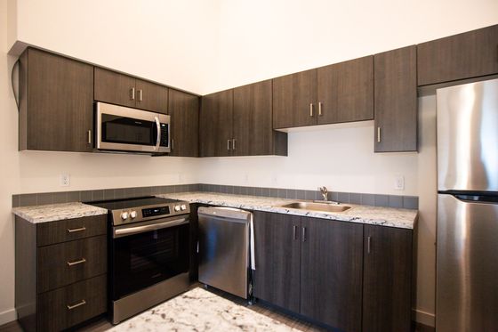 kitchen with dark cabinets and stainless steel appliances at Pacific Ridge Apartments