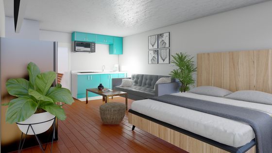 Stunning studio apartment with a modern bed, vibrant teal kitchen, and cozy living area.