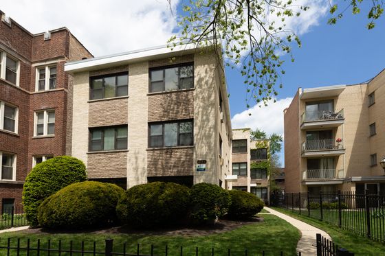 1644 West Sherwin a twelve unit mid century property with a yellow brick exterior and a landscaped front yard in Rogers Park.