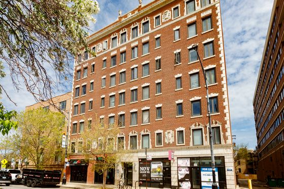 Seven story brick red brick building with limestone trim and retail on the 1st floor