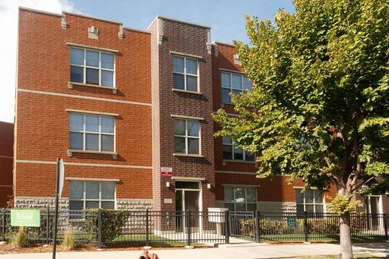 Harvest Homes a 36 unit three story red brick income restricted property with limestone accents in Garfield Park.